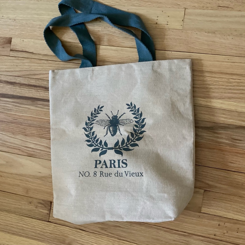 NWOT “Paris” motif Canvas shopper. Beige w/ green. Coated interior.